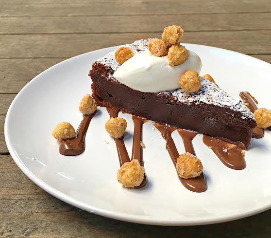 Flourless Nutella Cake with candied hazelnuts and fresh whipped cream. // Photo: @sherriesavorsthecity